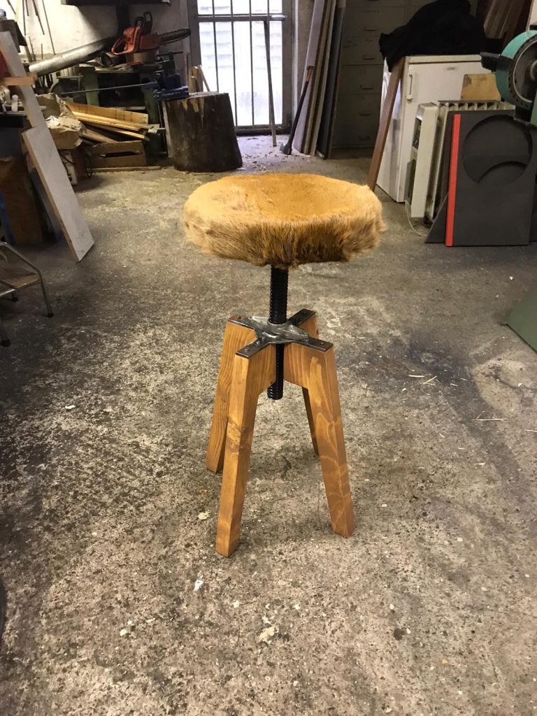 Hocker mit Holzbeinen und Fell