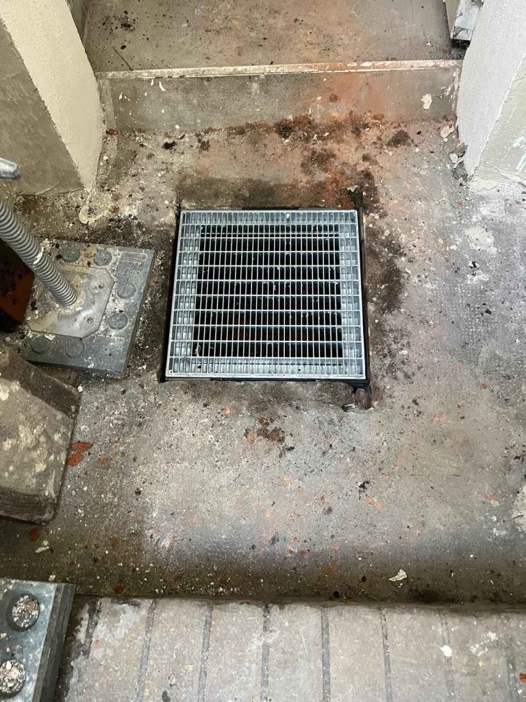 Bodenablauf mit Metallgitter im Betonboden