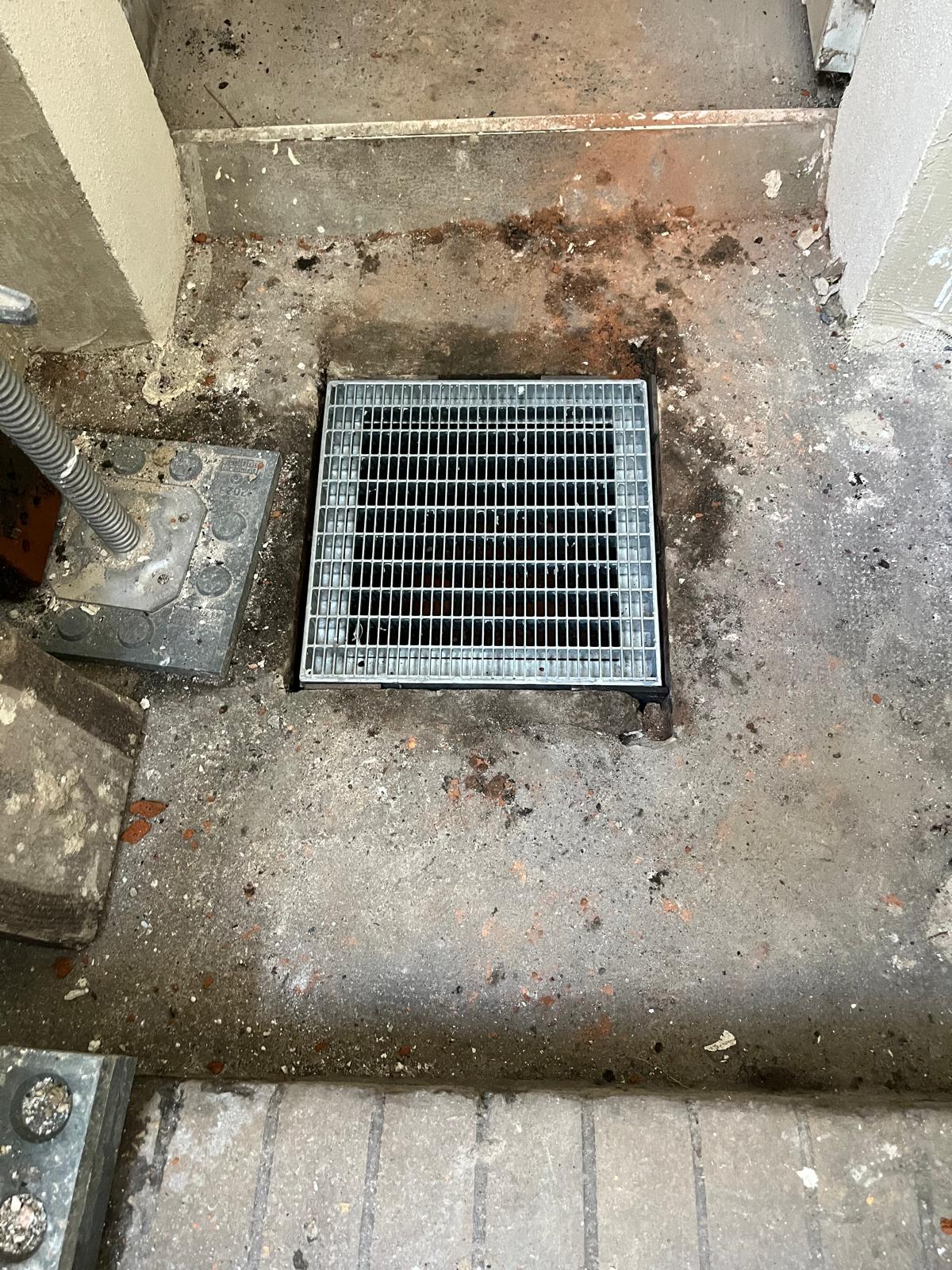 Bodenablauf mit Metallgitter im Betonboden